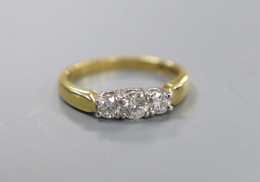 A modern 18ct gold and plat, three stone diamond set ring, size M, gross weight 4.1 grams